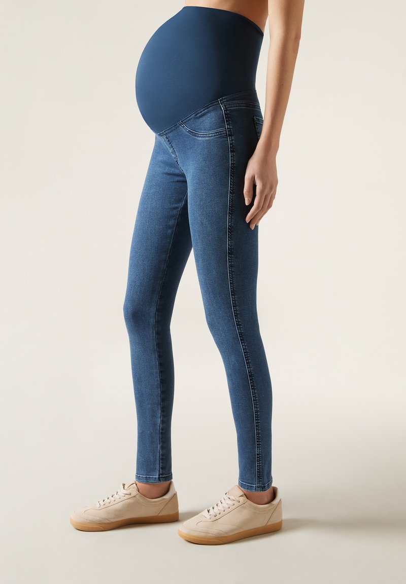 Leggings de maternidad en denim azul oscuro con una cintura alta y elástica; diseño ajustado con detalles de costura sutiles y bolsillos laterales.