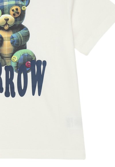 Maglietta bianca con una grafica di un orso a scacchi con bottoni, accompagnata dalla scritta "SORROW" in caratteri grassetto blu navy.