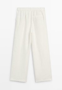 Pantalon en lin blanc avec une ceinture élastique, coupe droite, poches latérales et une poche arrière unique. Texture lisse.
