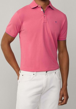 Polo de manga corta en color rosa con cuello con solapa, con colores contrastantes en el cuello y los bordes de las mangas.