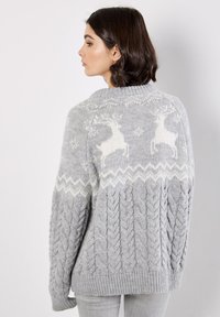 Grau gestrickter Pullover mit einer Struktur aus Zopfmuster, weißem Rentier-Muster und geripptem Saum. Verfügt über einen runden Ausschnitt und eine lockere Passform.