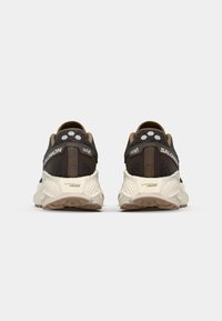 Black and brown athletic shoes with a textured design, white accents, round heel, and a cushioned, textured sole with energy foam branding.