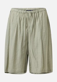 Shorts amples beige clair avec une ceinture élastique et un cordon, en tissu texturé avec des poches latérales.