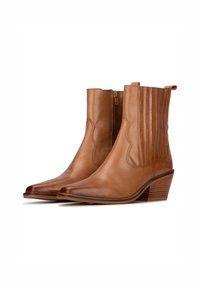 Tan leather ankle boots with a pointed toe, side zipper, and vertical ribbed accents on the upper. Featuring a stacked heel for support.