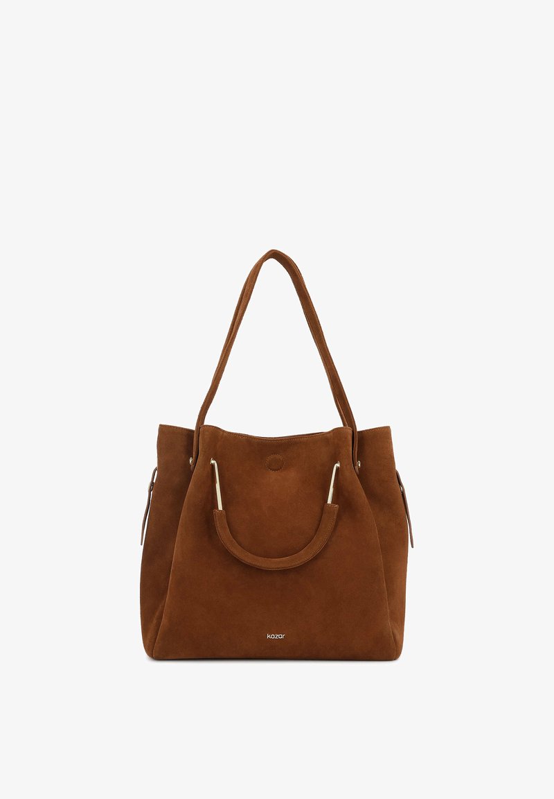 Sac cabas en daim marron avec double poignée, détails métalliques sur les petites poignées avant, et nom de la marque "kazar" au centre inférieur avant.