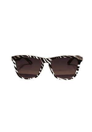 Gafas de sol con patrón de cebra en blanco y negro, diseño de ojo de gato y lentes oscuros. Cuentan con montura de plástico grueso y textura suave.