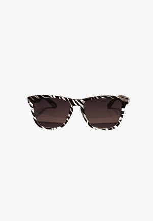 Gafas de sol con patrón de cebra en blanco y negro, diseño de ojo de gato y lentes oscuros. Cuentan con montura de plástico grueso y textura suave.