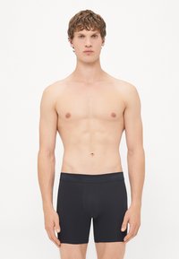 Zwarte katoenen boxer shorts met een zachte tailleband met daarop het "Calvin Klein" logo in blauw, aansluitend ontwerp, mid-thigh lengte.
