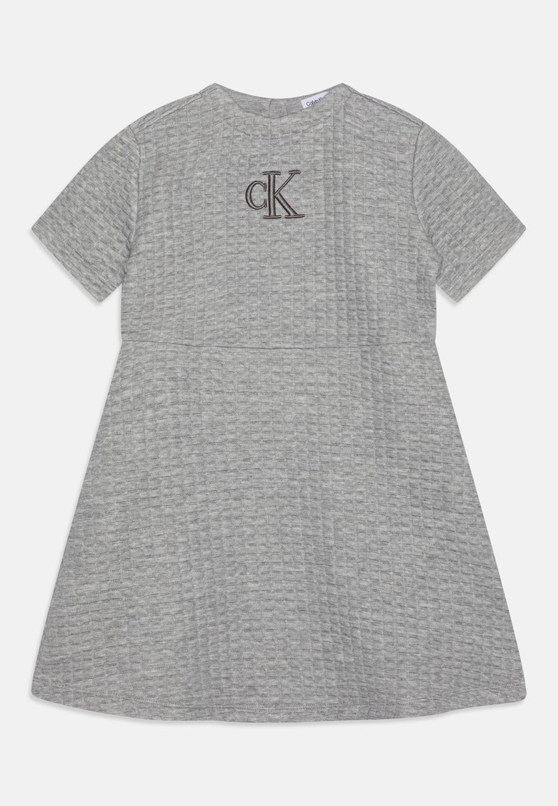 Grå bomullsklänning med korta ärmar, rund halsringning, texturerat tyg och en kontrasterande brun broderad "CK"-logotyp på bröstet.