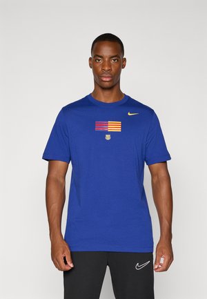 Blue cotton T-shirt featuring a horizontal striped pattern in red and yellow, a central emblem, and a small Nike logo on the shoulder.