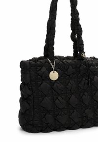 Schwarze gesteppte Tragetasche mit gepolstertem Rautenmuster, gerafften Griffen und einem kleinen runden goldenen Anhänger an einer Kette.