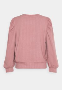 Różowy sweter z długim rękawem, z delikatnym wzorem w zygzaki, bufiaste rękawy, dopasowane mankiety i ściągacz w pasie, pokazany z tyłu.