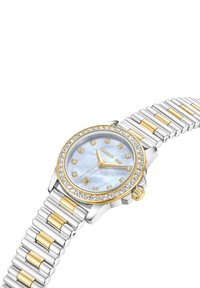 Sudraba un zelta toņu pulkstenis ar pērļu seju, kristāla akcentiem, apaļu rāmi un teksturētu metāla aproci. Datuma rādītājs pulksten 6.