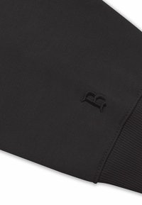 Sort sweaterstof med en struktureret finish. Har en ribbet manchet og en subtil syet logo detalje på ærmet.