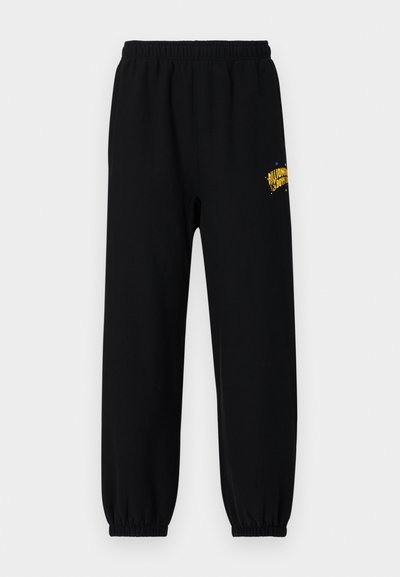 Pantaloni de trening negri din bumbac, cu un brâu elastic și manșete elastice, având un logo grafic galben pe piciorul drept.