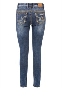 Slim-fit dunkelblaue Jeans mit einer ausgebleichten Textur, dekorativer Ziernaht an den Gesäßtaschen und einem Leder-Logo-Patch am Bund.