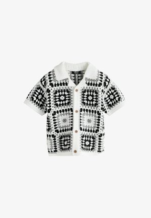 Chemise boutonnée à manches courtes en crochet noir, blanc et gris avec un col texturé et des motifs géométriques carrés.