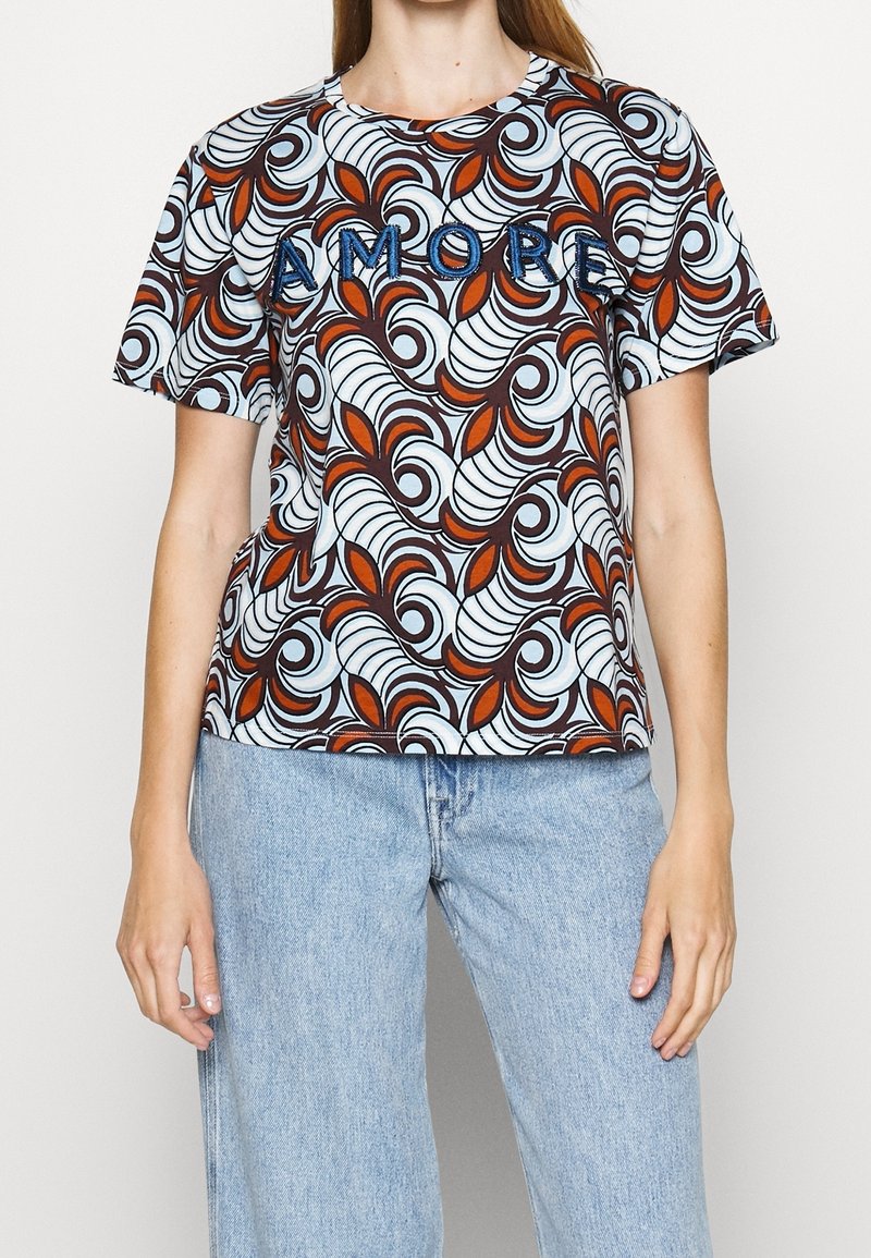 Short-sleeved t-shirt in a patterned fabric featuring swirls and leaves in brown, white, and orange, with "AMORE" embroidered in blue.