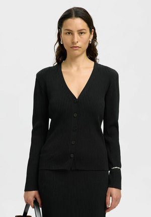 Svart ribbad cardigan med V-hals, långa ärmar och sex knappar. Inkluderar en silverdetalj vid ärmslutet. Mjuk stickad textur.