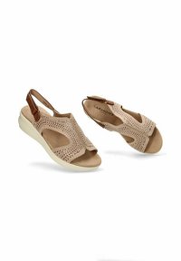 Sandalias beige con parte superior de ante perforado, diseño tipo slingback y suela acolchada de color crema. Presenta acentos en cuero marrón.