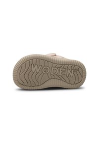 Svijetloružičasta gumena podloga tenisica s teksturiranim, valovitim uzorkom. Logotip "WODEN" istaknuto je prikazan. Materijal izgleda kao guma s izdržljivim uzorkom na potplatu.
