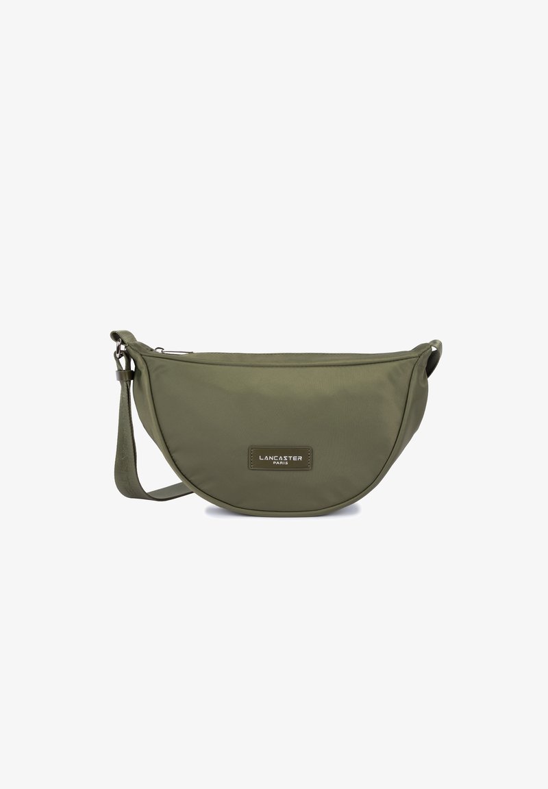 Borsa a spalla in tessuto verde oliva con forma curvata, dotata di una tracolla e un'etichetta con logo sulla parte anteriore. Texture liscia e chiusura a zip.