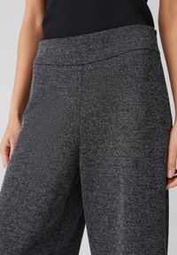 Graue strukturierte weit geschnittene Hosen mit einem glatten Bund, die ein dezentes gesprenkeltes Muster aufweisen und durch den lockeren Sitz für Komfort sorgen.