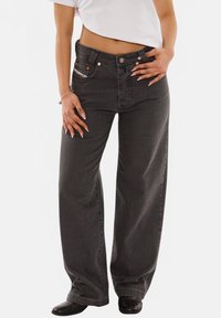 Wide-leg dark gray jeans made of denim, featuring a high waist, four pockets, copper hardware, and a subtle striped pattern along the waistband.