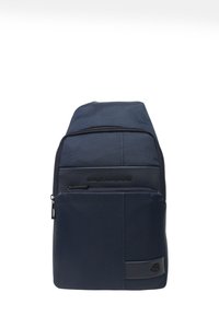 Zaino a tracolla Piquadro blu navy con due scomparti con zip e una toppa con il logo sulla tasca anteriore.