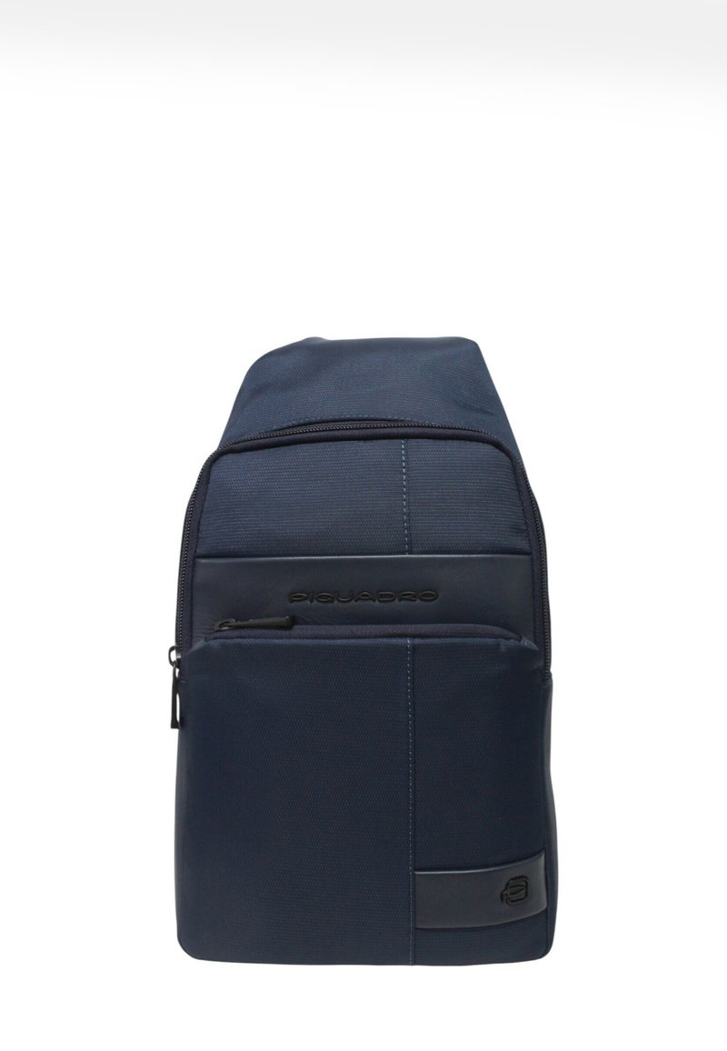Zaino a tracolla Piquadro blu navy con due scomparti con zip e una toppa con il logo sulla tasca anteriore.