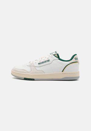 Baskets en cuir blanc avec des accents verts, semelle en caoutchouc gomme, col rembourré et logo Reebok sur le côté et la languette. Design bas classique.