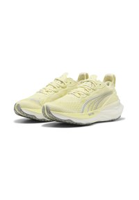 Baskets de course Puma en jaune clair, avec un upper en maille texturée, des accents argentés réfléchissants, une semelle rembourrée et une semelle extérieure en caoutchouc à motif.
