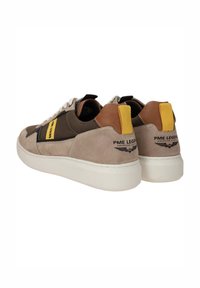 Tan en bruine suède sneakers met een witte rubberen zool. Voorzien van een gele label en zwarte accenten. MerklLogo op de hiel. Vetersluiting.