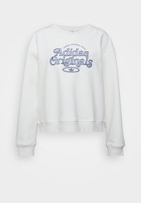 Vit sweatshirt med rund halsringning och sänkta axlar. Har blå broderad text "Adidas Originals" tillsammans med logotyp. Mjuk, bomullsblandad material.