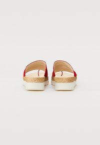 Piros slip-on szandál, nyitott hátú, textúrált barna parafa talppal és fehér középtalppal. Puha szövet felső rész minimalista dizájnnal és varrási részletekkel.