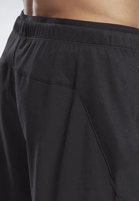 Svarta träningsshorts med avslappnad passform, som har resårmidja, slät yta och en sidoficka med meshdetaljer.