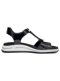 Black patent leather open-toe sandal with adjustable straps and white cushioned sole designed for comfort and casual wear.