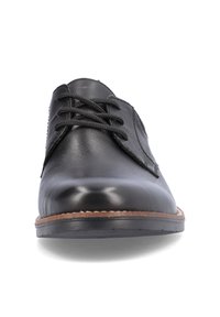 Chaussure en cuir noir à lacets avec une texture lisse, bout rond et semelle en caoutchouc, présentant des coutures subtiles le long du bord.