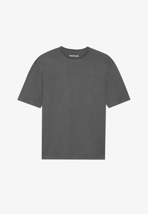 Szürke pamut póló kerek nyakkal, rövid ujjal és laza fazonnal. Sima textúrával rendelkezik, és egyszerű designja van, grafikák nélkül.