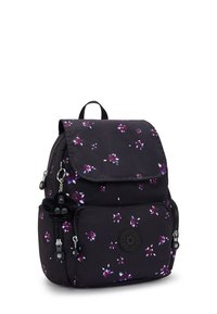 Svart tygryggsäck med lila blommönster, magnetisk lucka, fickor med dragkedja och en nyckelringscharm. Rund logotypdetalj framtill.