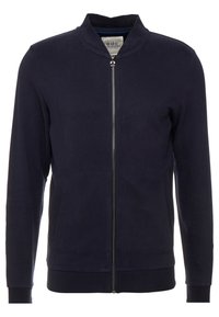 Granatowa kurtka zapinana na zamek z prążkowanym kołnierzem, mankietami i dołem, z dwoma bocznymi kieszeniami i srebrnym zamkiem błyskawicznym na środku.