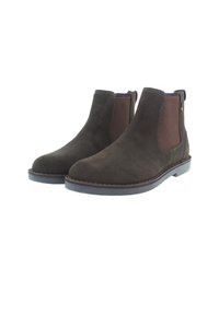 Botas Chelsea de ante marrón con paneles laterales elásticos, punteras redondas y detalles de costura sobre una suela de goma plana.