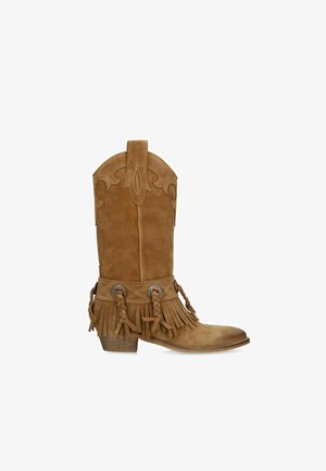 Bruine suède cowboylaars met gestikte details, franjes, gevlochten leren riemen, metalen concho's en een lage houten hak.