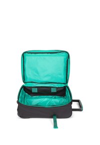 Černá cestovní taška s tyrkysovým interiérem. Má zipové uzavření, prostorný vnitřek a dvě upevňovací popruhy uvnitř. Rukojeť na jedné straně.
