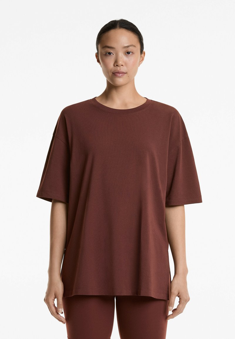 Oversized bordeaux t-shirt van zacht, ademend materiaal. Heeft een ronde halslijn en korte mouwen, met een ontspannen, rechte pasvorm.