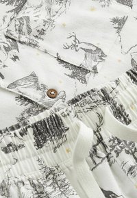 Baumwoll-Pyjama-Set mit weißem Stoff, verziert mit grauen Wald- und Hirschmustern, brauen Knopfdetails und einem elastischen Bund mit weißen Kordeln.