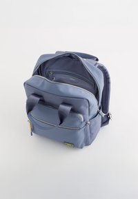 Mochila azul marino hecha de tejido suave, con un bolsillo frontal, dos asas superiores y cremalleras plateadas. El interior incluye un bolsillo adicional con cremallera.