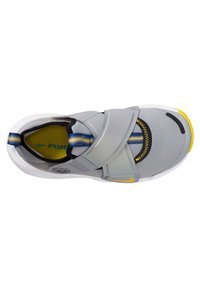 Chaussures de sport grises avec une fermeture à sangle, une semelle intérieure jaune et une semelle extérieure texturée avec un élément de design noir et jaune.