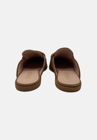 Sandali slip-on in suede marrone con una soletta in pelle liscia e bordi arrotondati; caratterizzati da cuciture minime e un logo impresso sulla soletta.