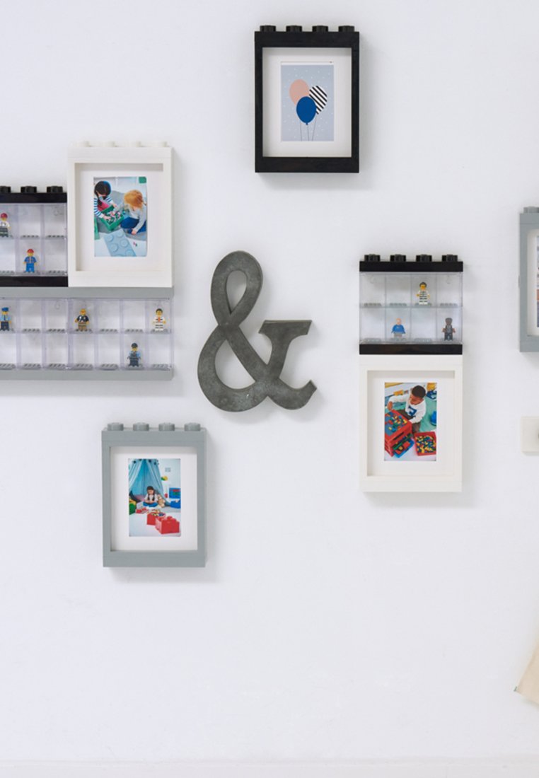 Wieloramkowy wyświetlacz w różnych kolorach: czarnym, białym i szarym. Teksturowane i gładkie powierzchnie prezentują obrazy i mini-figury. Symbol „&” jest wyraźnie widoczny.